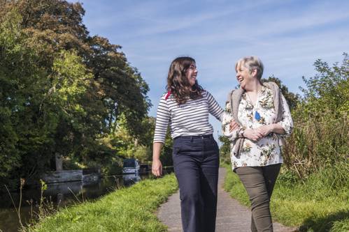 Two women walking on canal path