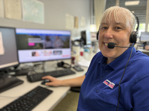 A photograph of a Nottingham on Call operative wearing a head set and smiling