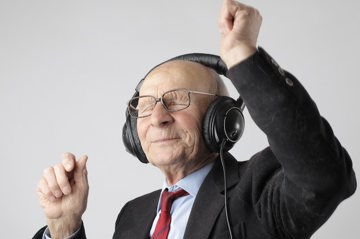 Old man listening to podcast on headphones